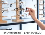 Hand of  woman choosing the glasses in optics store, eyesight and vision concept 