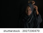 Muslim mothers dress traditional muslim style with Niqab veil for daughter, on black background