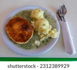 Small photo of Traditional Pie, Mash and Liquor. Pie and Mash is a Cockney classic meal consisting of a minced beef pie, mashed potato and a parsley sauce known as liquor.
