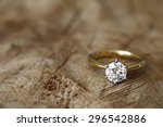 Solitaire engagement diamond ring won wooden organic background. 