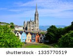 Colorful row houses with towering cathedral in background in the port town of Cobh, County Cork, Ireland