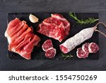 Small photo of Meat appetizer platter with sausage, and Italian cold cuts. Above view on a slate serving board.