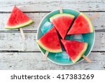 Watermelon slice popsicles on a vintage blue plate and rustic wood background