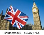 United Kingdom flag waving in bright blue sky in front of the Houses of Parliament at Westminster Palace with Big Ben
