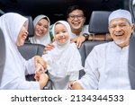 Small photo of Three generation Muslim family travelling by car while homecoming to celebrate Eid Mubarak