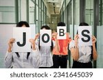 Group of business people covering their face with JOBS writing on papers