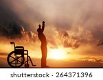 A disabled man standing up from wheelchair at sunset. Positive concept of cure, recovery, medical miracle, hope, insurance etc. 