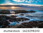 Sunset  And Waves On Rocks At...