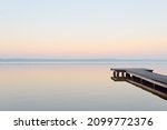 Small photo of Forest lake (river) at sunrise. Wooden pier (boardwalk). Soft sunlight, mist, reflections on water. Idyllic autumn landscape. Pure nature, ecotourism, hiking, exploring