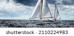 Small photo of Old expensive vintage wooden sailboat (yawl) close-up, sailing in an open sea. Dramatic cloudscape. Coast of Maine, US