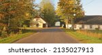 Small photo of An old country asphalt road through the village and alley of oak trees. Traditional house close-up. East Germany. Autumn rural scene. Architecture, agriculture, farm, ecology. countryside, ecotourism