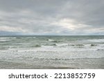 Small photo of Baltic sea during the storm. Dramatic sky, dark glowing clouds. Waves, water splashes. Idyllic seascape. Climate change, nature, fickle weather, ecology