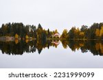 Forest lake (river) on a cloudy day. Country house, cottage. Reflections in water. Gloomy sky after the rain. Finland. Idyllic autumn landscape. Pure nature, ecology, ecological reserve, ecotourism