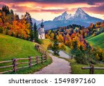 Iconic picture of Bavaria with Maria Gern church with Hochkalter peak on background. Fantastic autumn sunrise in Alps. Superb evening landscape of Germany countryside. Traveling concept background.