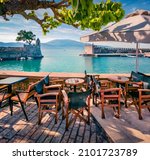 Small photo of Empty beach cafe in Nafpaktos town. Stunning morning scene of Gulf of Corinth, Greece, Europe. Vacation concept background.