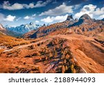 Colorful autumn view from flying drone top of Falzarego pass. Majestic autumn scene of Dolomite Alps with Torre Grande Cima Ovest peak on background, Italy, Europe. Traveling concept background.