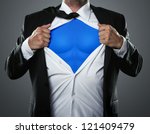 Young businessman acting like a super hero and tearing his shirt off with copy space