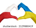 Human hands, painted with Poland and Ukraine flags,  forming heart shape isolated on white background