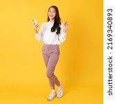 Small photo of Smiling asian woman white shirt on yellow background use smartphone with happy feeling show appreciation
