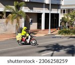 Small photo of BOWEN, QLD - NAY 08 2023:Australian Postman ride on a moped scooter bike to deliver post on city street.There are 7,950 postal routes serviced by 10,000 `posties` Nationwide
