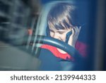 Small photo of Young girl talking on phone while driving car. Dangers of underage driving and inattentive on road. Selective focus on eyes.