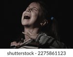 Small photo of Conceptual image: pain in children. Psychological portrait of nervous and overexcited young girl screams and wants to tear the t-shirt.