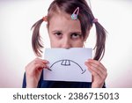 Small photo of Fake sadness, manipulation, fake facial expression, fake emotion and psychological trouble. Beautiful young girl holding banner with fake sad face expression.. Horizontal image.