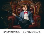 Handsome seven year old boy in elegant suit posing in luxurious apartments. Kid's fashion. 