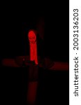Small photo of Scary devilish possessed nun with a cross in her hands kneels and prays standing in a dark room. Horrors and Halloween.