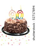 Small photo of Chocolate birthday cake surrounded by confetti with lit candle for a ninetieth birthday or anniversary celebration