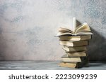 Vintage old hardback books, diary, fanned pages on wooden desk table and grunge background Daylight. Books stacking. Back to school. Copy Space. Education background