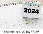 2024 year written in a notebook on a calendar.. 2024 plans with digital marketing concepts,business team and goals