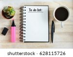 To do list written in a notebook / Notebook with an to do list on wooden desk with cup of coffee 