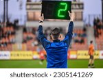 Small photo of Sideline referee shows 2 minutes added time during the football match.
