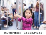 Small photo of Asian child cute or kid girl smiling enjoy in bogey of sky train or electric train with underground railways or subway and holding rail for happy travel or transportation fun in city street on holiday