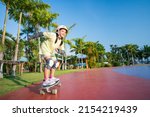 Small photo of asian child or kid girl smile playing surf skate or skateboard in skatepark and extreme sports exercise to wearing helmet elbow pads wrist and knee support for body safety protect at bang phra park