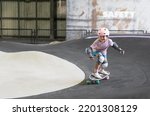 Small photo of asian child skater or kid girl fun playing skateboard or ride surf skate and turn on pump track in skate park by extreme sports to wearing helmet elbow pads wrist knee support for body safety protect