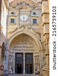 Small photo of Toledo, Spain - June 31, 2022. Puerta del Reloj Gate of the Toledo Prime Cathedral. View from Plaza del Ayuntamiento square. Toledo, Castilla La Mancha, Spain.