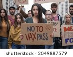 Young people marching with signs with novax slogans  - concept of young people protesting against the mandatory vaccine and vax pass