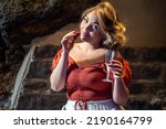 Small photo of Voluptuous woman eating strawberry fruits and drinking champagne looking at the camera - people at party drinking alcoholic drinks lifestyle concept