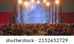 Small photo of intentionally blurred ideal as a backdrop with people spectators waiting for the start of the concert in the theater with the stage without any and customizable at will