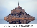 Small photo of famous monastery of Mont Saint Michel with the Abbey church built above the hill during high tide in northern France in the Normandy region