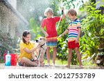 Kids Wash Dog In Summer Garden. ...