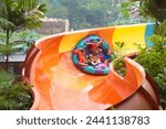 Kids on water slide in outdoor...