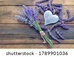 decorative metal heart among flowers of lavender on wooden background  