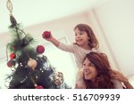 Mother and daughter decorating Christmas tree and having fun. Focus on the daughter