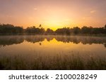 Forest reflection and mist fog on the water surface at sunrise in morning. Golden hour, Idyllic landscape and relax time concept