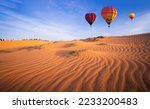 Small photo of Hot air balloons flying over beautiful sand dunes sunset in the Mui Ne Red Sand Dunes in the North of Mui Ne Village, about 25 km from Phan Thiet City, Vietnam