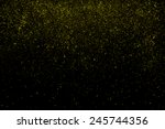 Freeze motion of gold powder coming down, isolated on black, dark background. Abstract design of falling yellow dust. Particles cloud screen saver, wallpaper with copy space. Rain, snow fall concept
