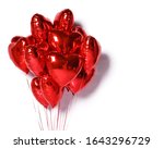 Bunch of metallic red color heart shaped foil balloons on white background. Set of air balloons, love and holiday valentines day celebration party decoration.